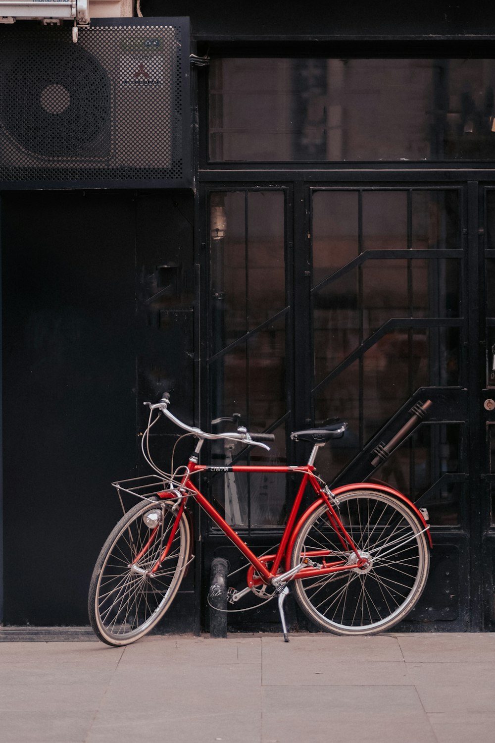 a red bike parked on the side of a building