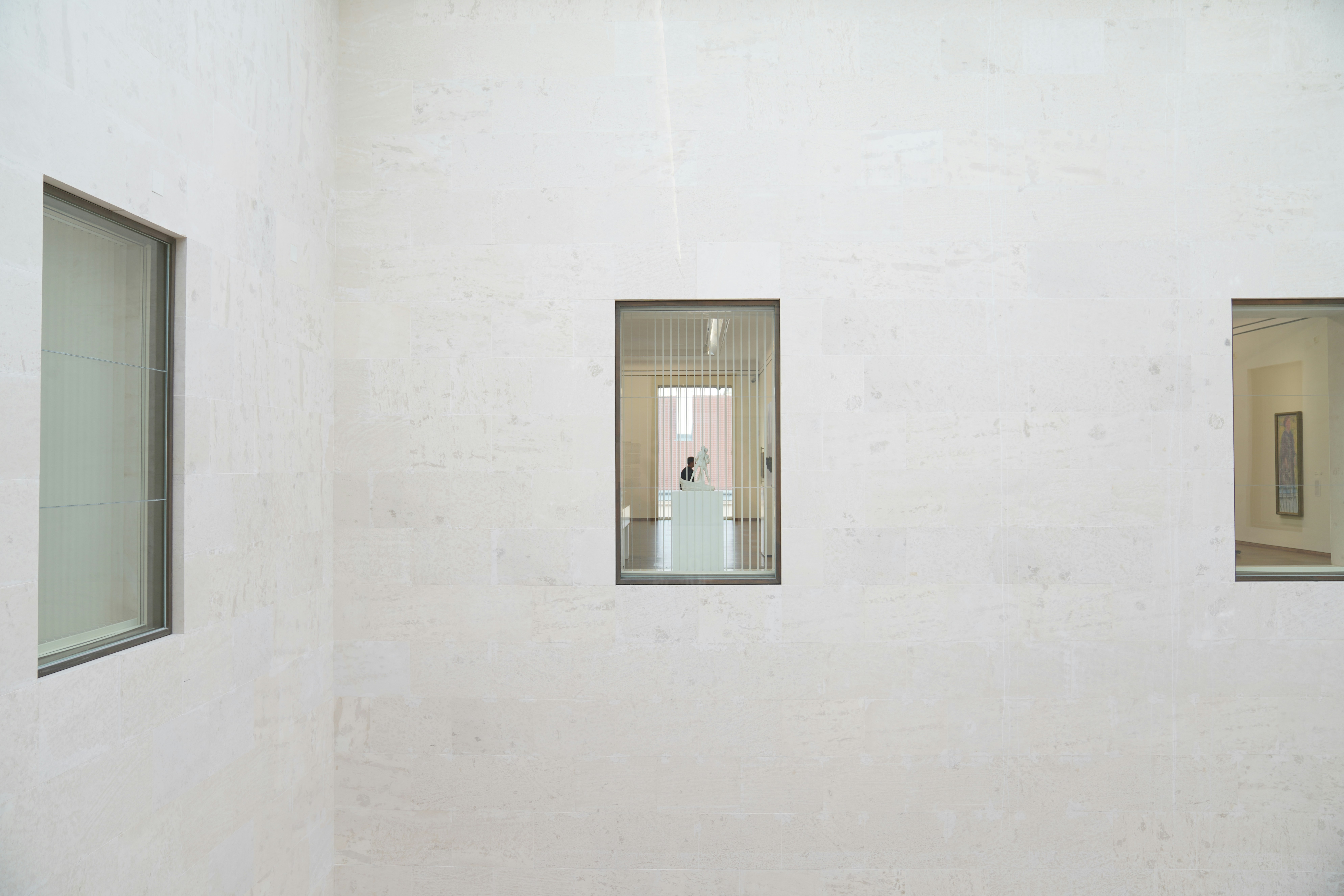 a white room with three windows and a white wall