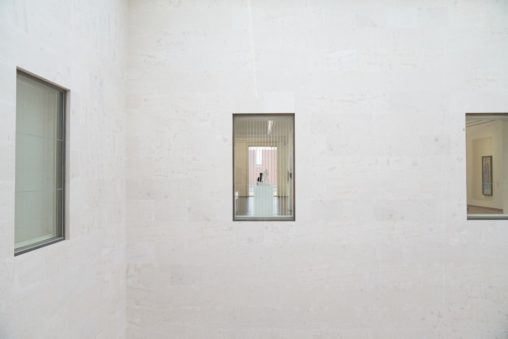 a white room with three windows and a white wall