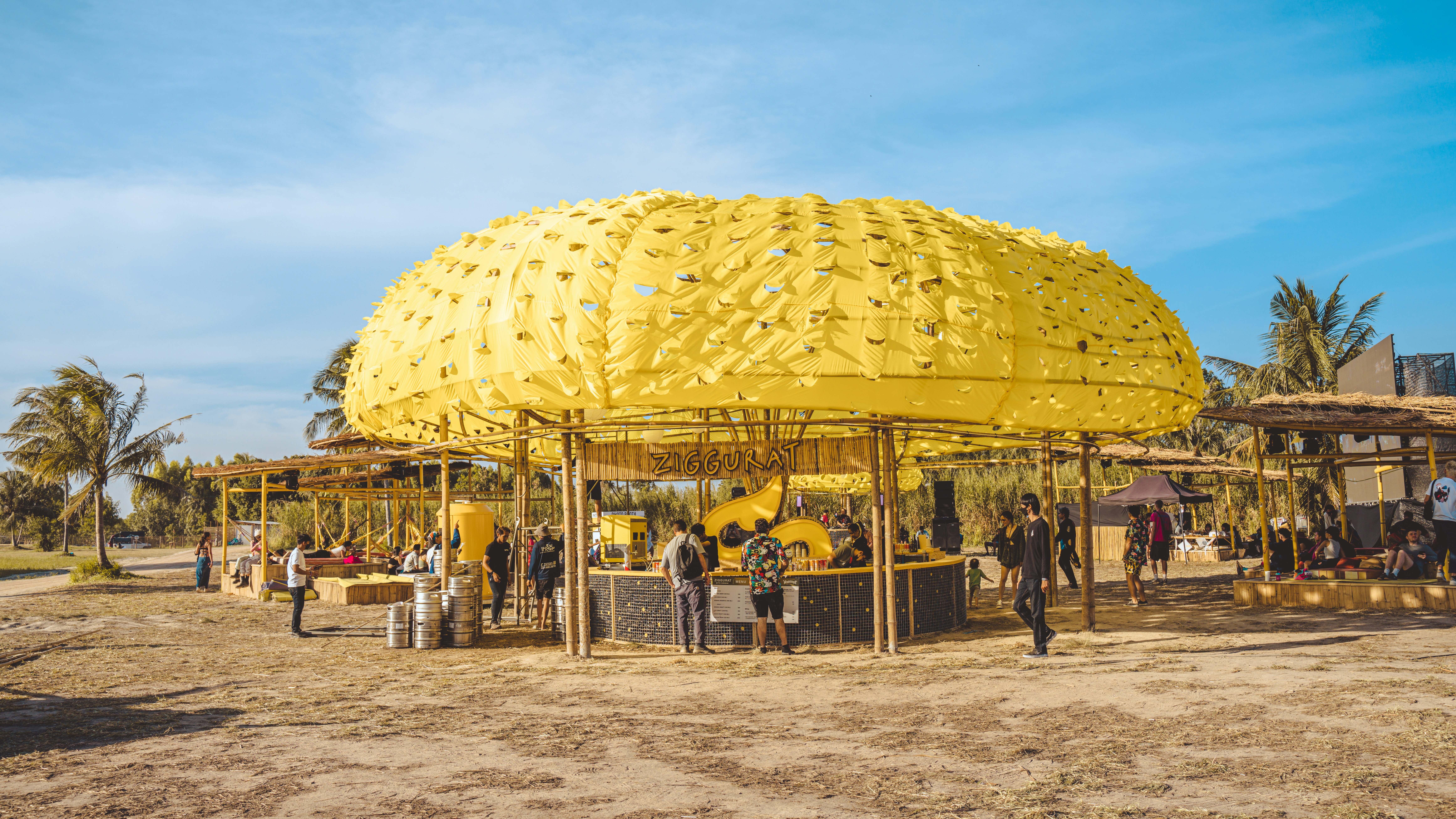a group of people standing around a yellow structure