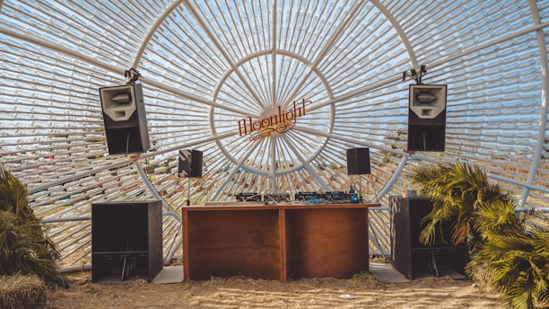 A cozy DJ set in a rustic barn surrounded by nature at sunset.