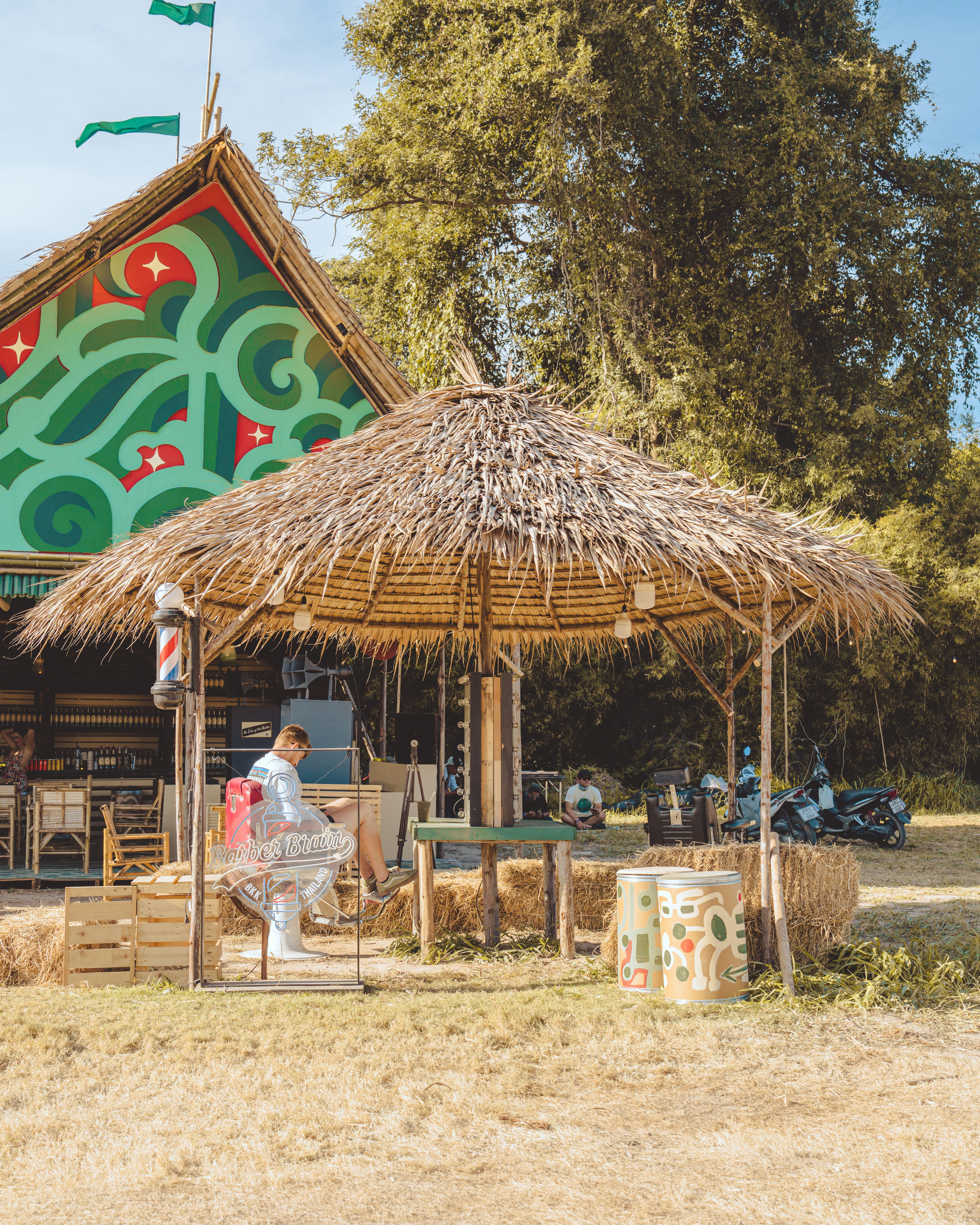 a straw hut with a thatched roof and a woman standing in front of it