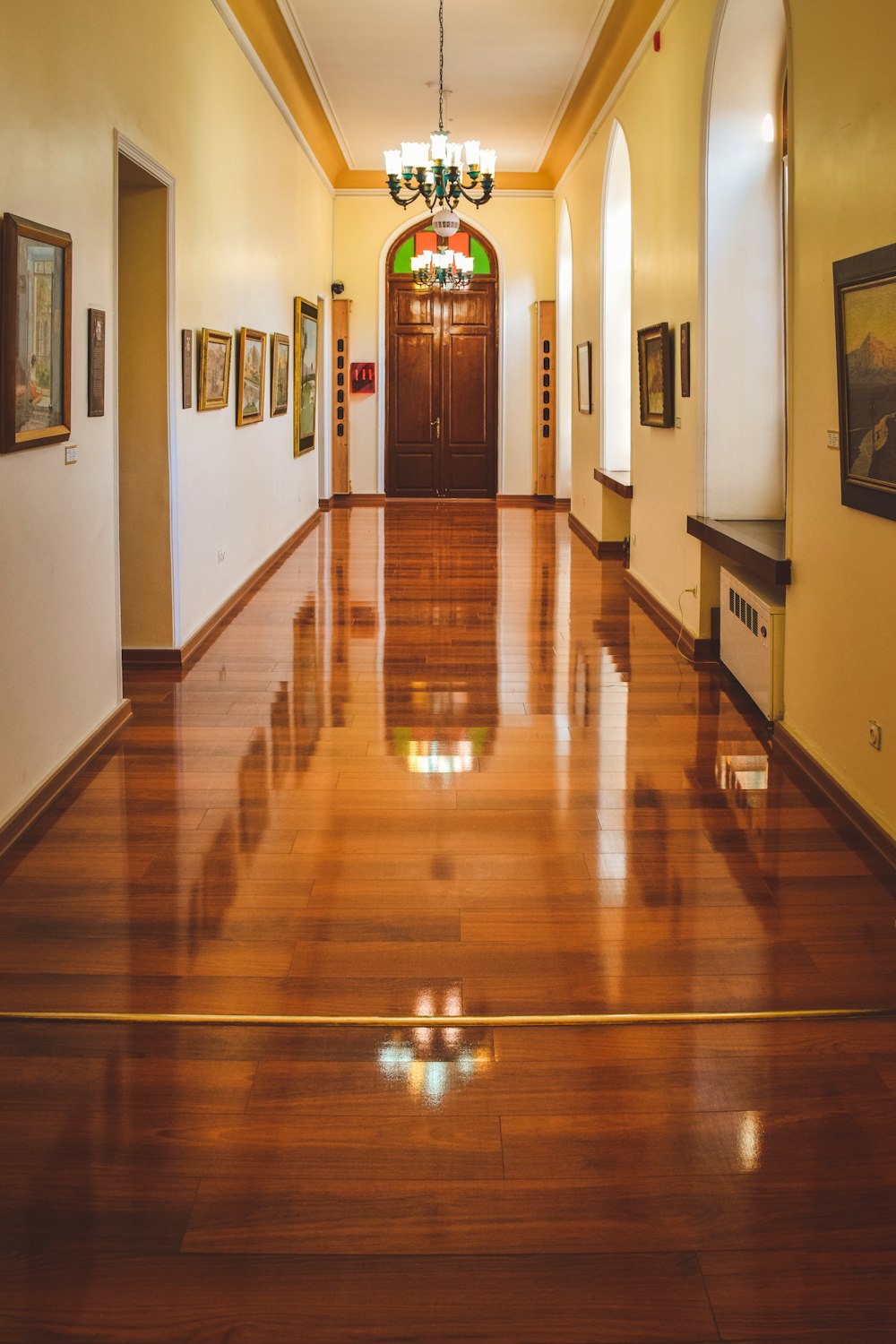 a long hallway with a chandelier hanging from the ceiling