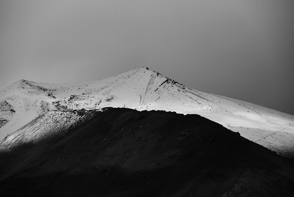 a black and white photo of a snow covered mountain