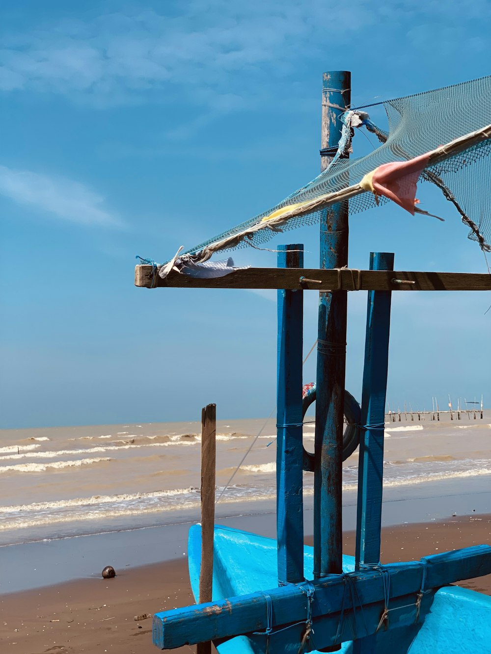 a blue boat sitting on top of a sandy beach