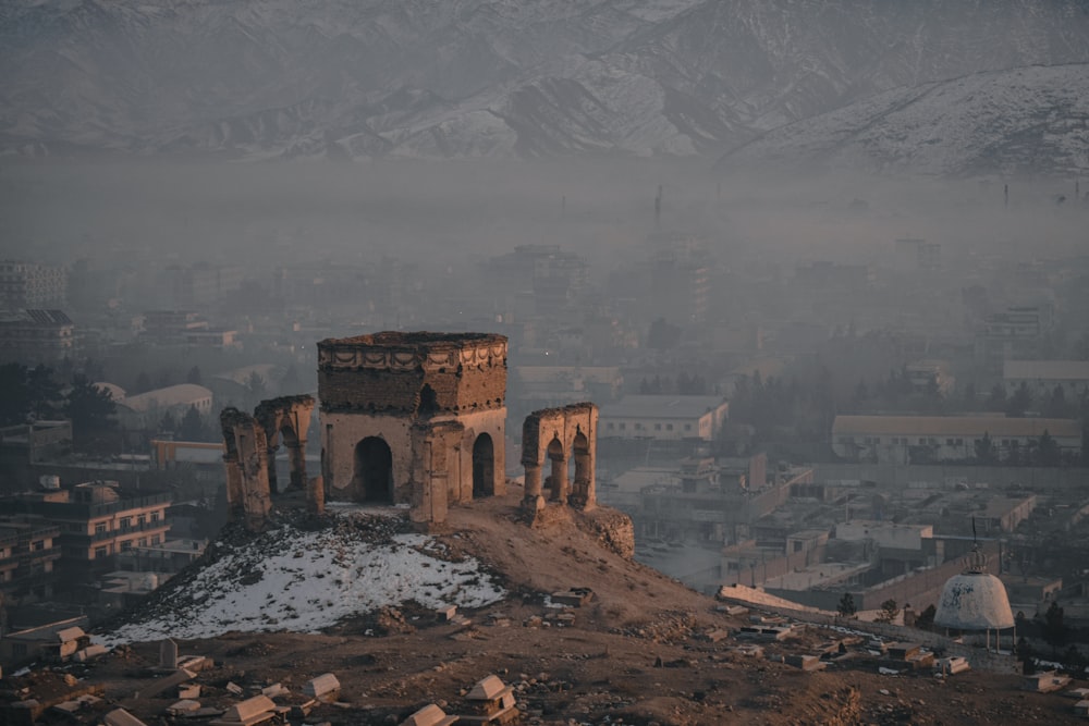 an old building on top of a hill with snow on the ground