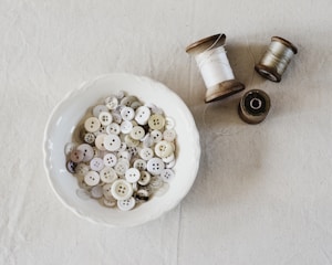 Close-up of colorful buttons and delicate laces arranged neatly on a wooden table.