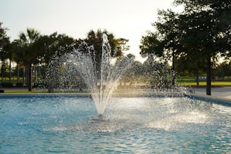 a fountain with water spouting from it in a park