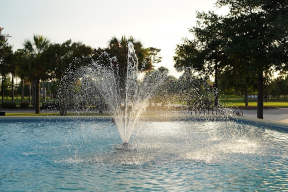 a fountain with water spouting from it in a park