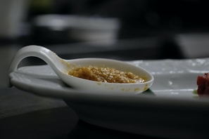 Close-up of golden pure desi ghee in a traditional clay pot with a wooden spoon