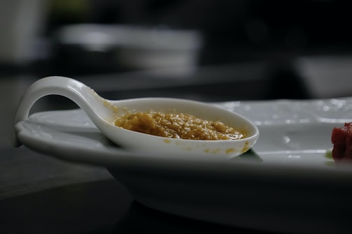 Close-up of a spoonful of creamy baby puree with a soft pastel background