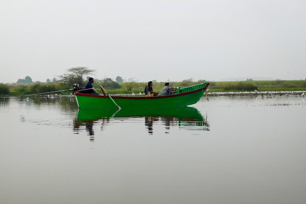 a group of people in a green boat on a body of water