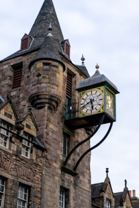 a clock mounted to the side of a brick building