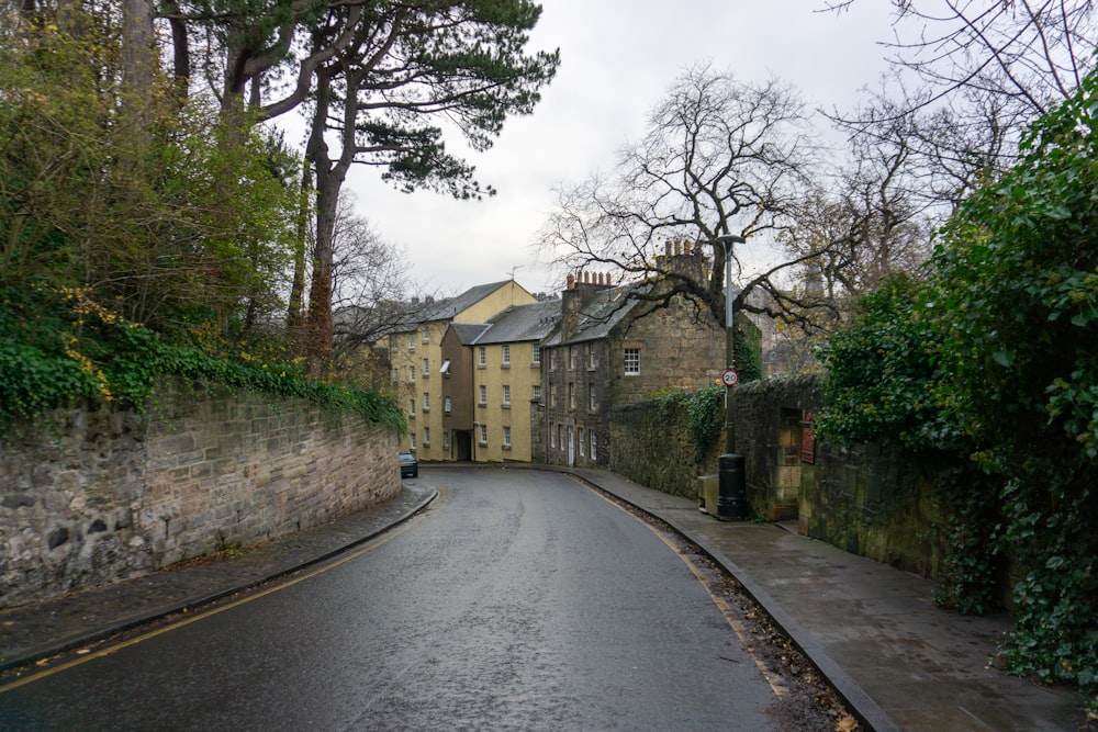 a narrow street with a stone building on the side