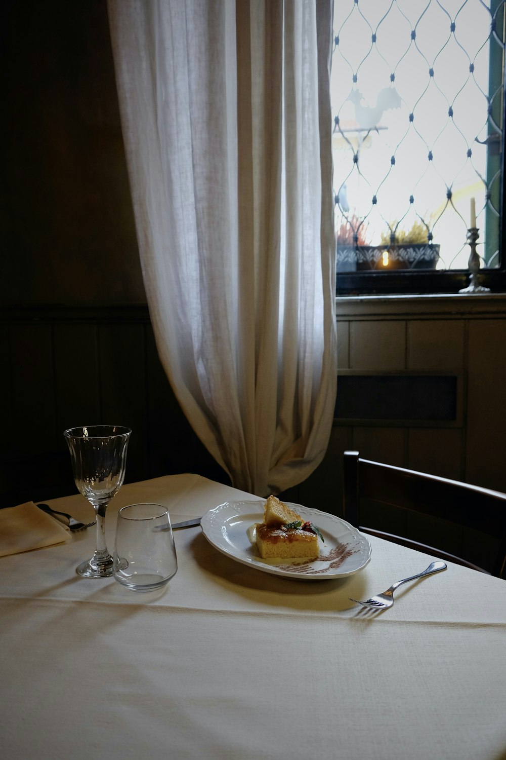 a table with a plate of food and a wine glass