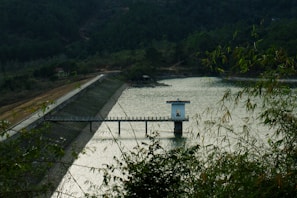 The tranquil Laxmipur Dam nestled among rolling hills, inviting peaceful moments by the water