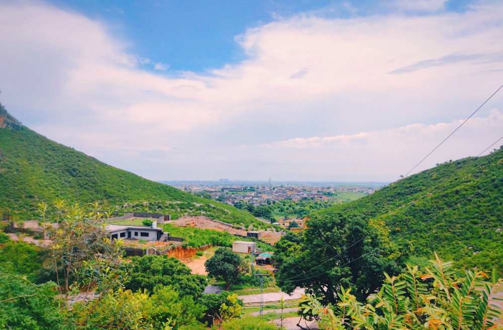 a scenic view of a valley with houses in the distance