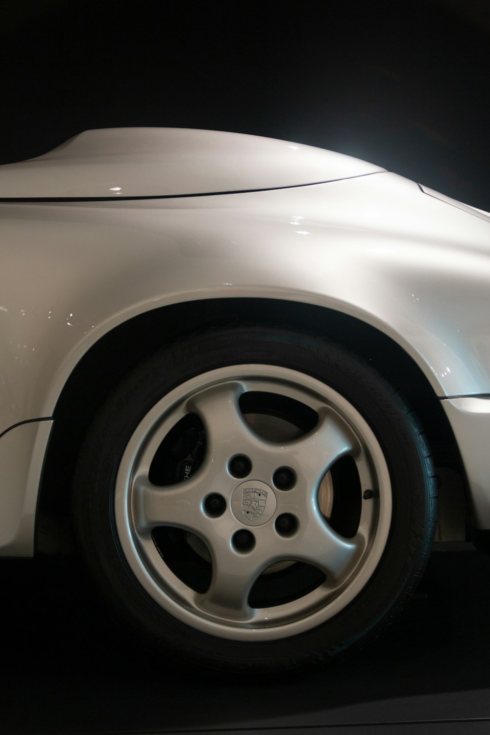 a close up of a white sports car on display