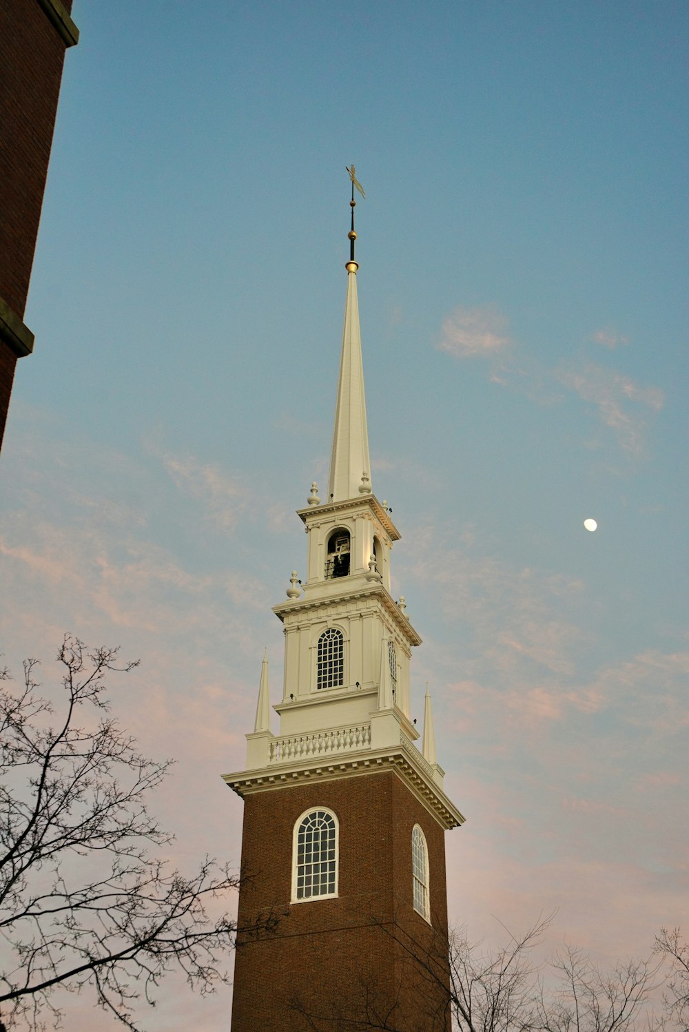 a church steeple with a moon in the background