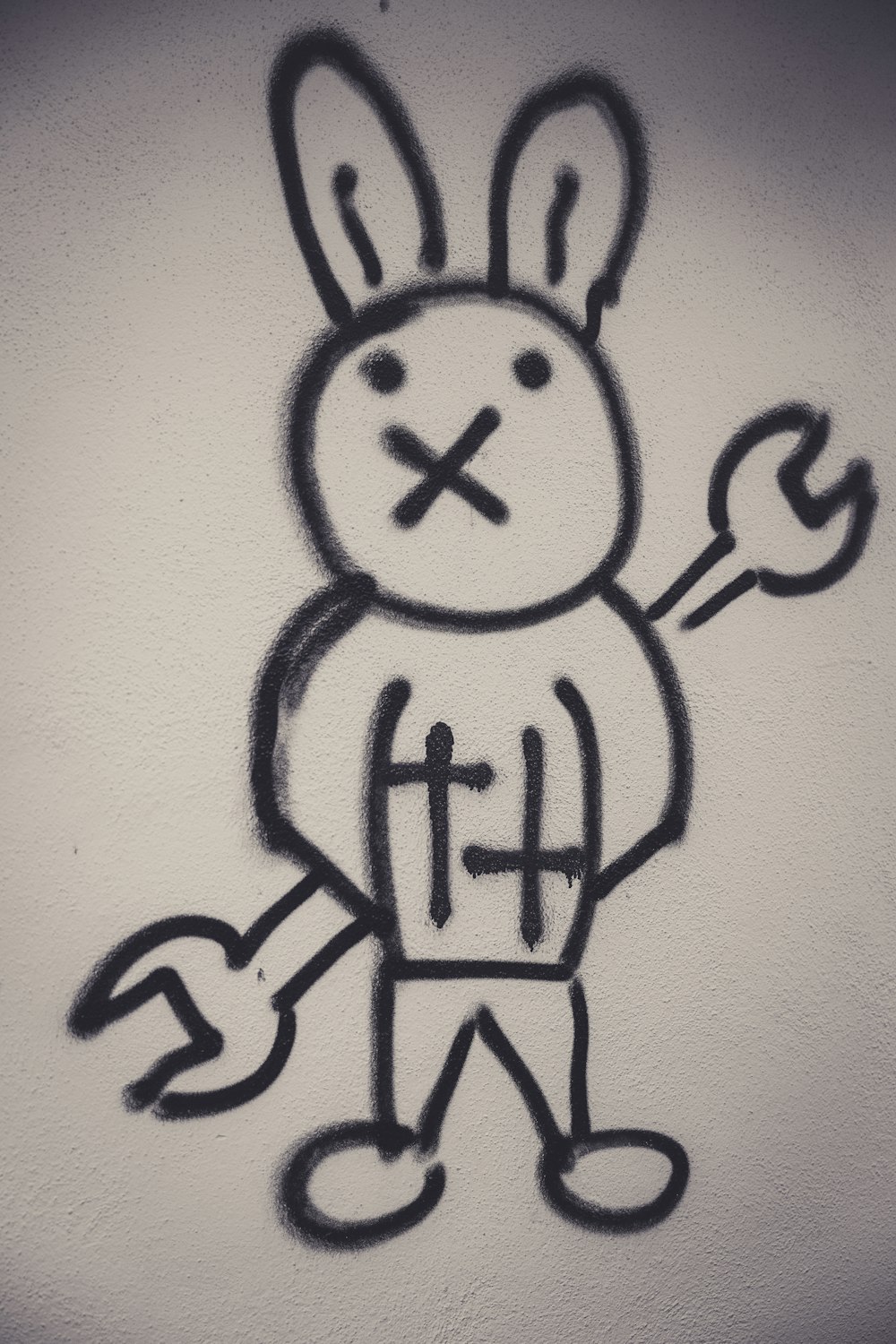 a drawing of a rabbit holding a wrench