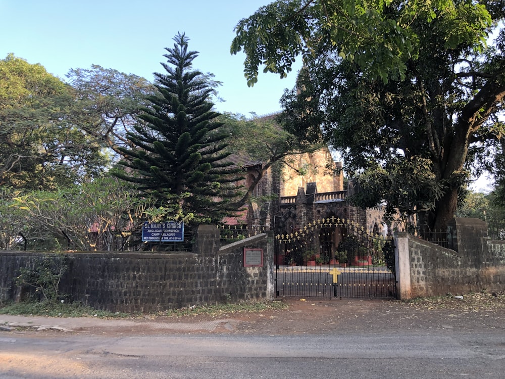 a house with a gate and a tree in front of it