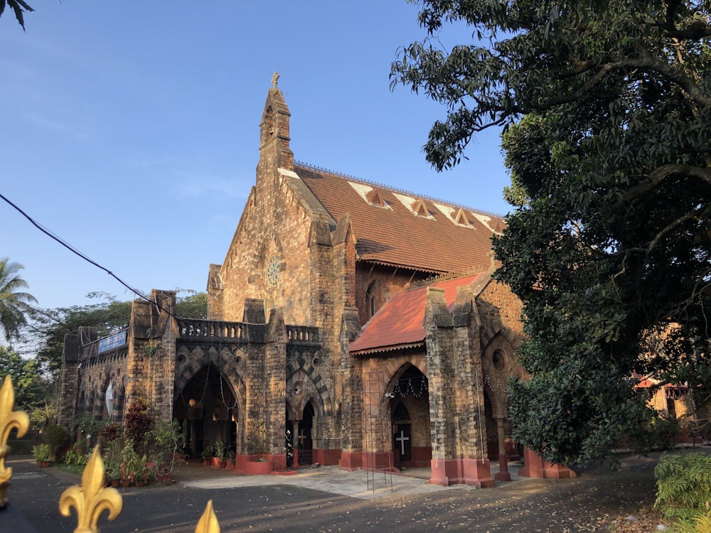 an old church with a red roof surrounded by trees