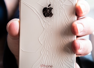 a person holding a broken iphone in their hand