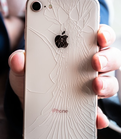 a person holding a broken iphone in their hand