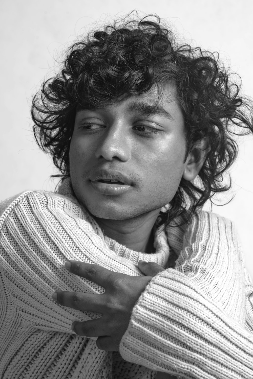 a black and white photo of a man with curly hair