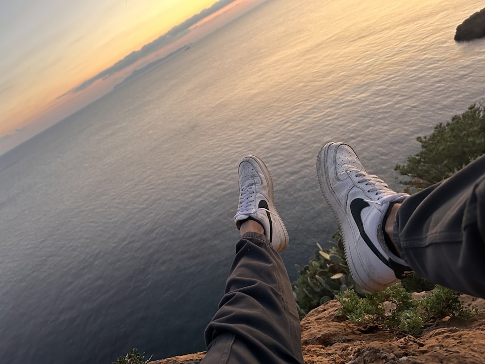 a person sitting on top of a cliff overlooking the ocean