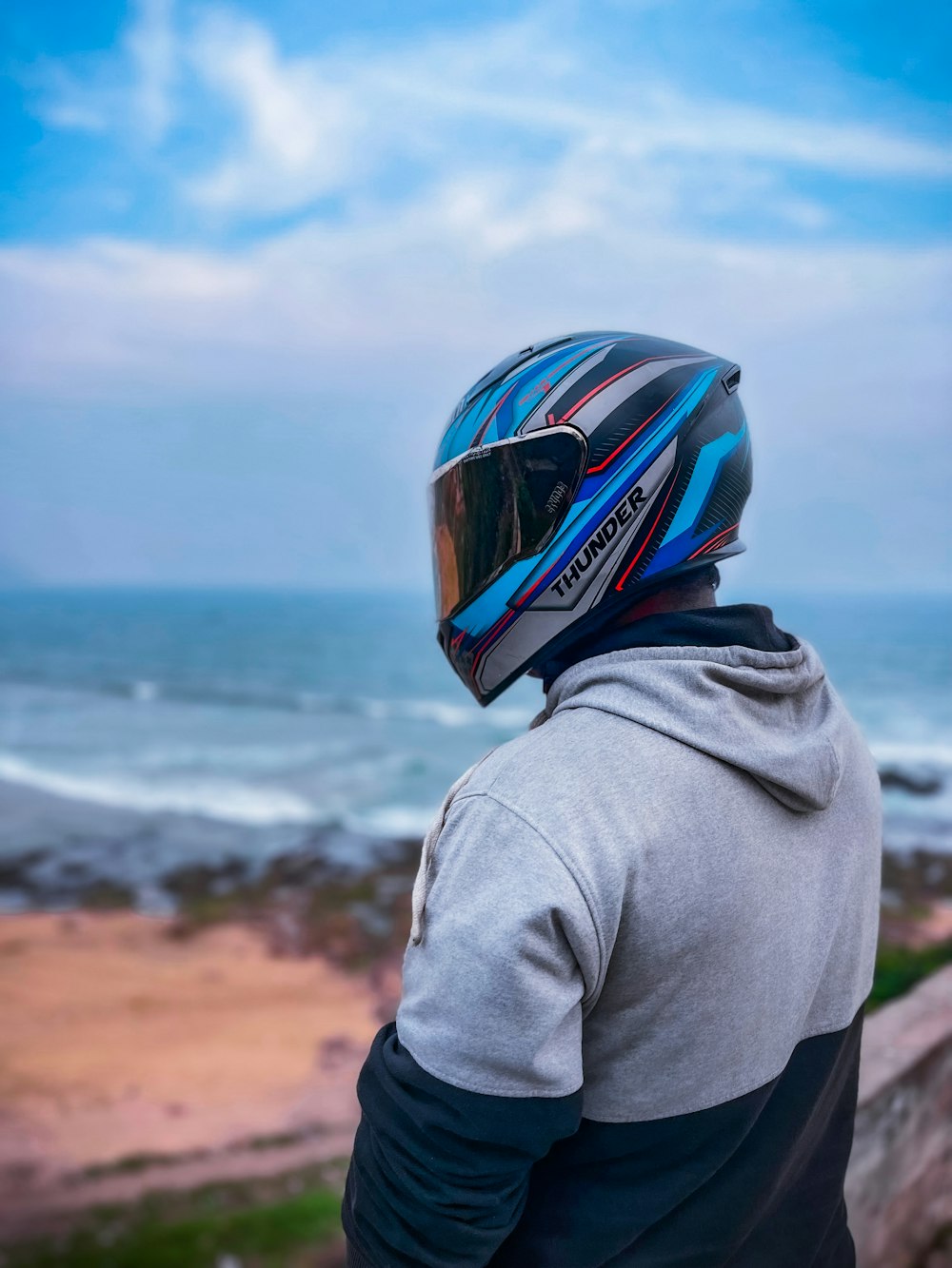 a man wearing a helmet looking out at the ocean
