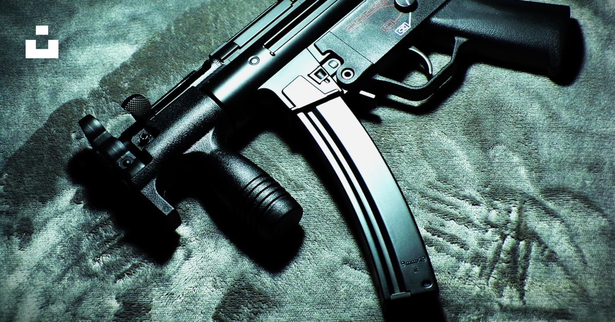 A close up of a gun laying on a bed photo – Free Firearm Image on Unsplash