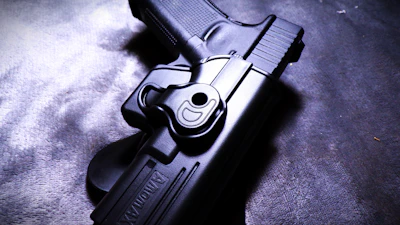 Close-up of detailed revolver resting on worn leather holster