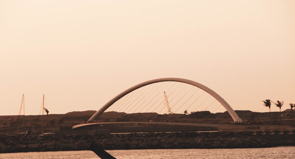 a person on a surfboard in front of a bridge