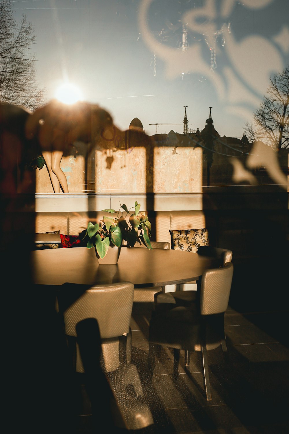 a table with chairs and a vase with flowers on it