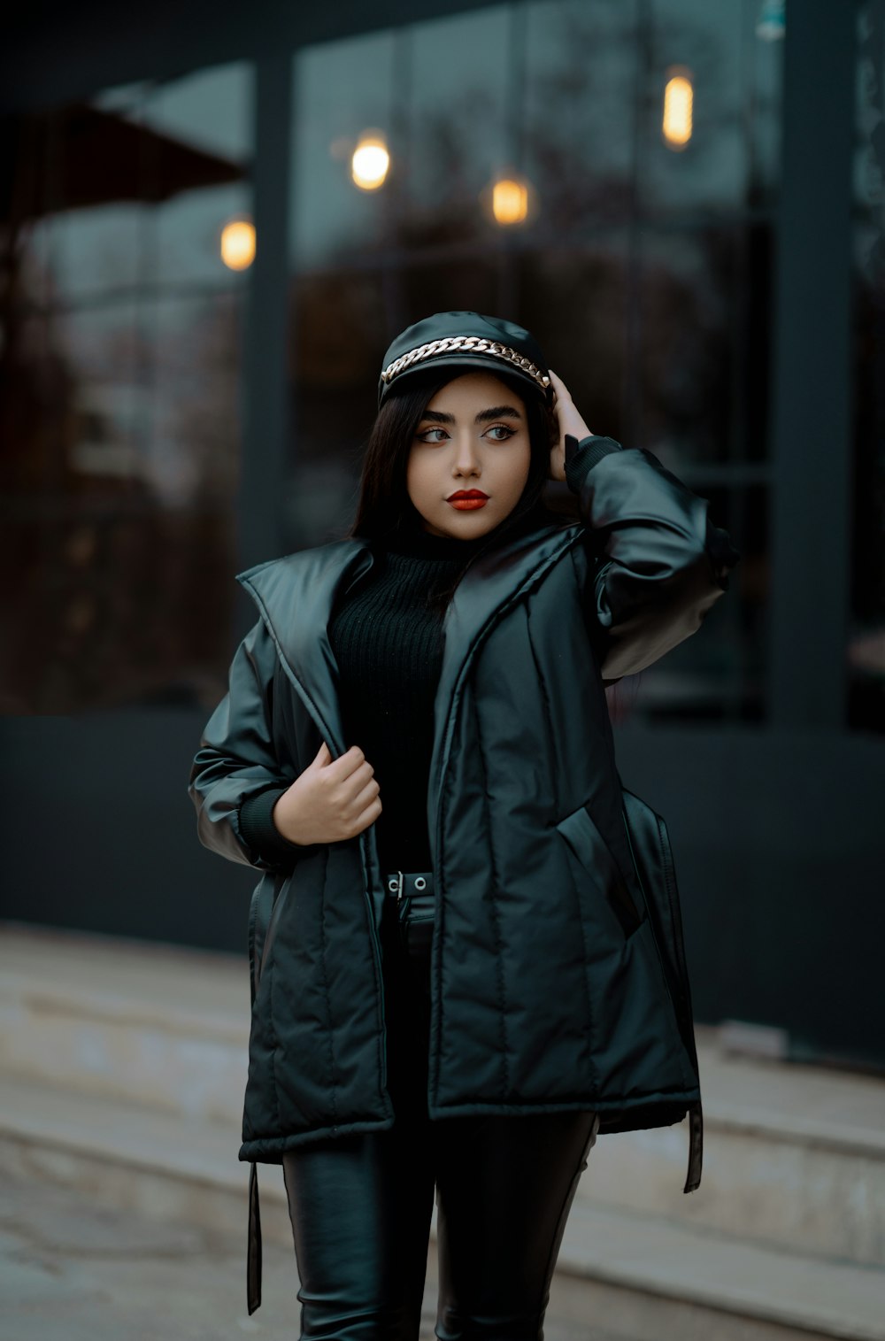 a woman wearing a black jacket and a hat