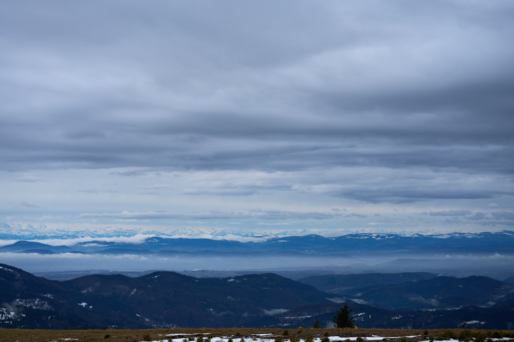 a view of a mountain range with snow on the ground