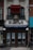 A two-story building with a brick facade featuring a storefront labeled 'N'awlins'. There are signs advertising 'Cajun - Italian Dining' and 'Live Jazz' with a phone number. The windows have 'For Lease' signs with contact details. A red canopy covers a balcony above.