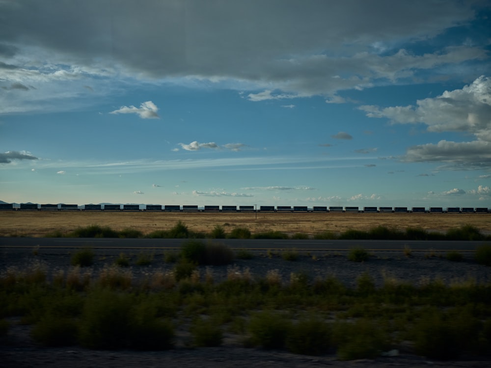 a train traveling through a rural countryside under a cloudy sky