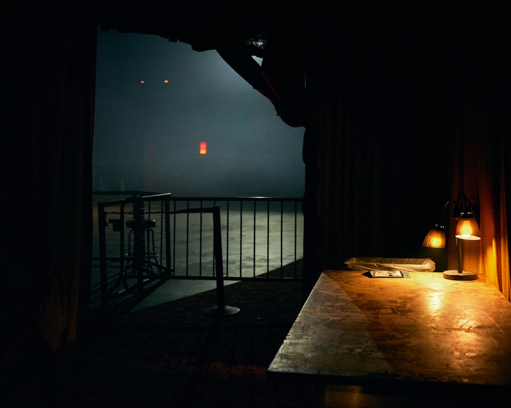 a table with a lamp on it in a dark room