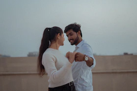 A couple sitting together, holding hands and smiling during a session.