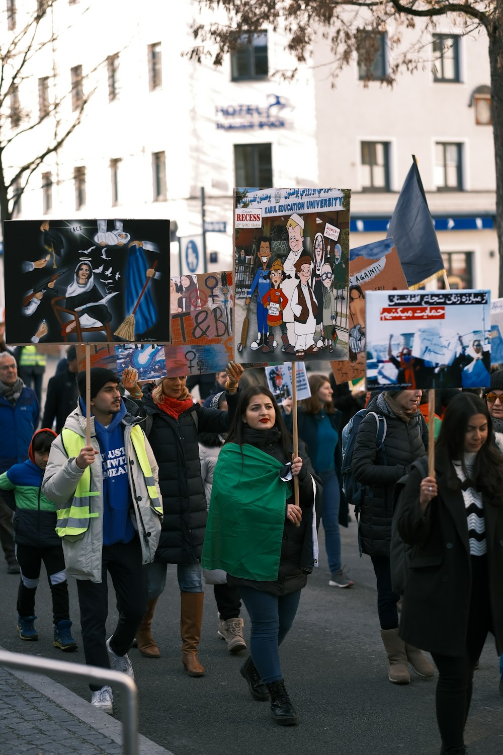 um grupo de pessoas andando por uma rua segurando cartazes
