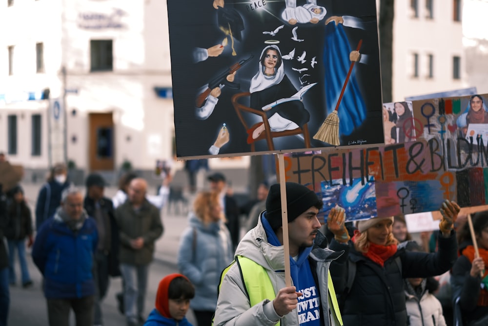 a group of people walking down a street holding signs