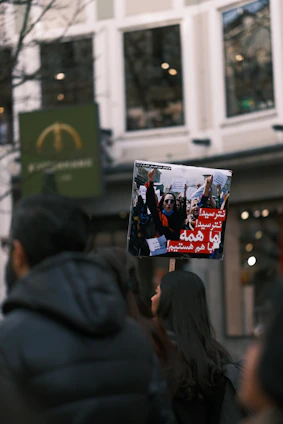 A poignant photograph of an Iranian family holding hands amidst a backdrop of peaceful protest.