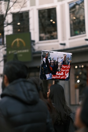 Close-up of passionate Iranian demonstrators chanting slogans in a public gathering.