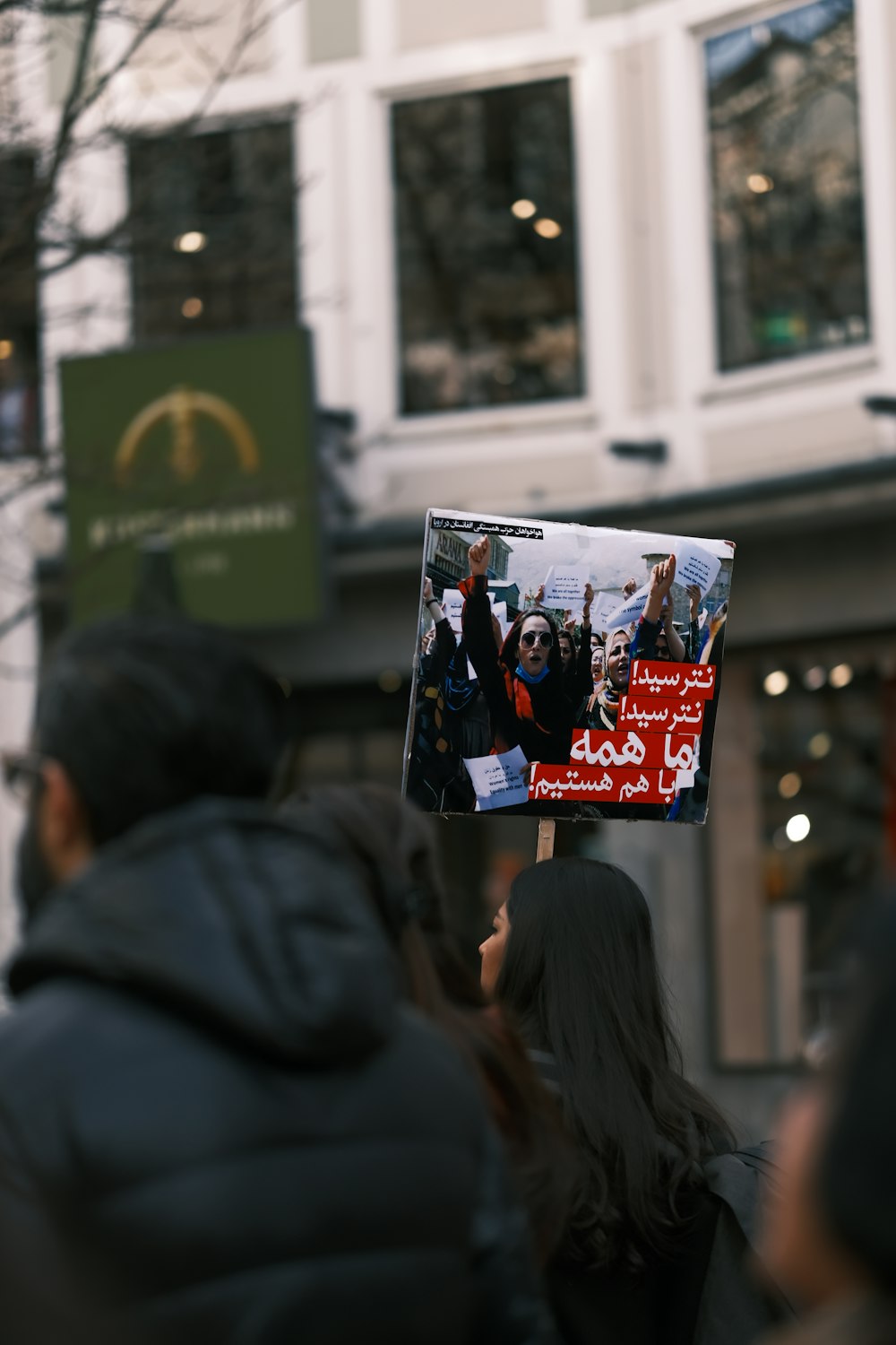 a person holding a sign in front of a building