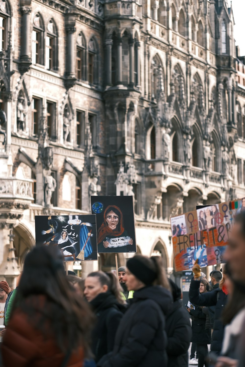 a group of people holding signs in front of a building