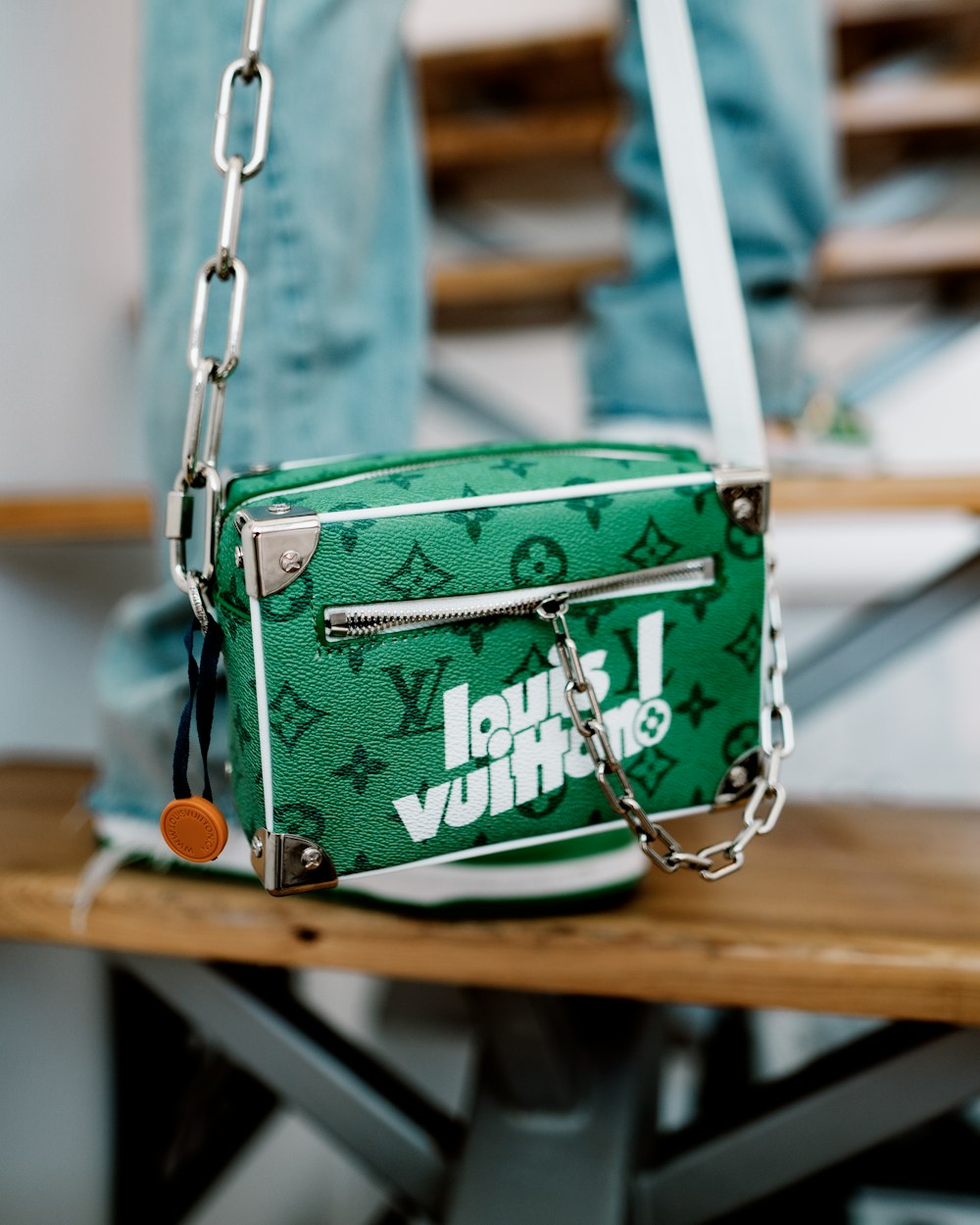 A green louis vuitton bag sitting on top of a wooden table photo