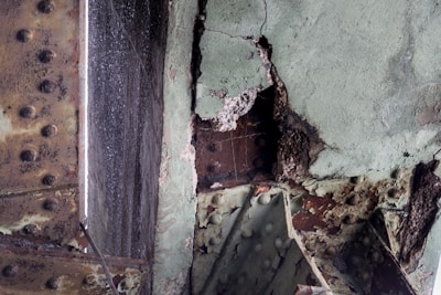 Rusted and deteriorating metal structure with visible corrosion and peeling paint, highlighting significant wear and decay over time.
