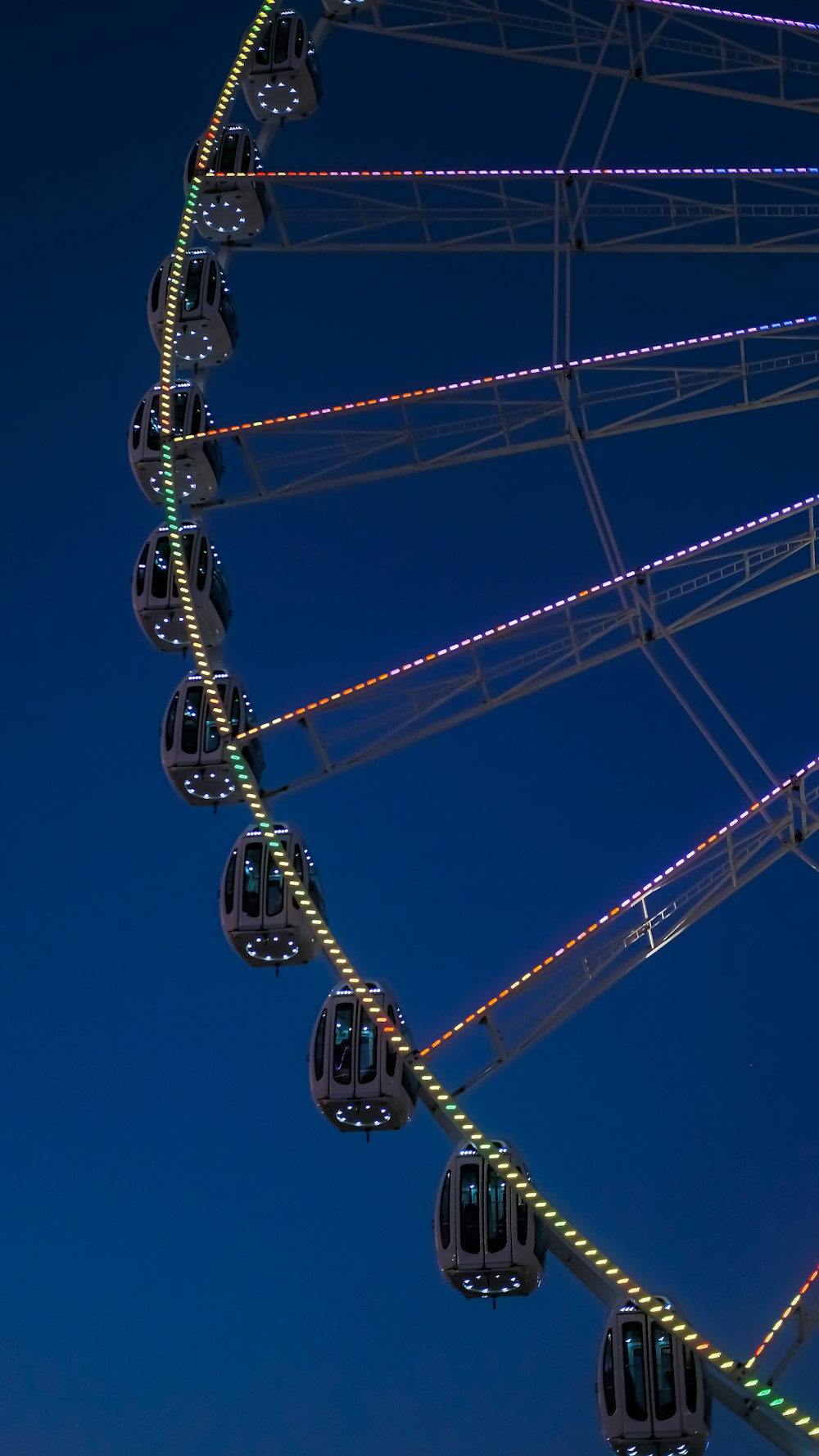 a ferris wheel lit up at night in the sky